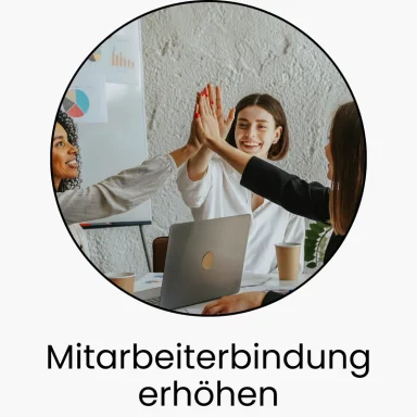 Drei Personen feiern Erfolge mit High-Fives in einem Büro.